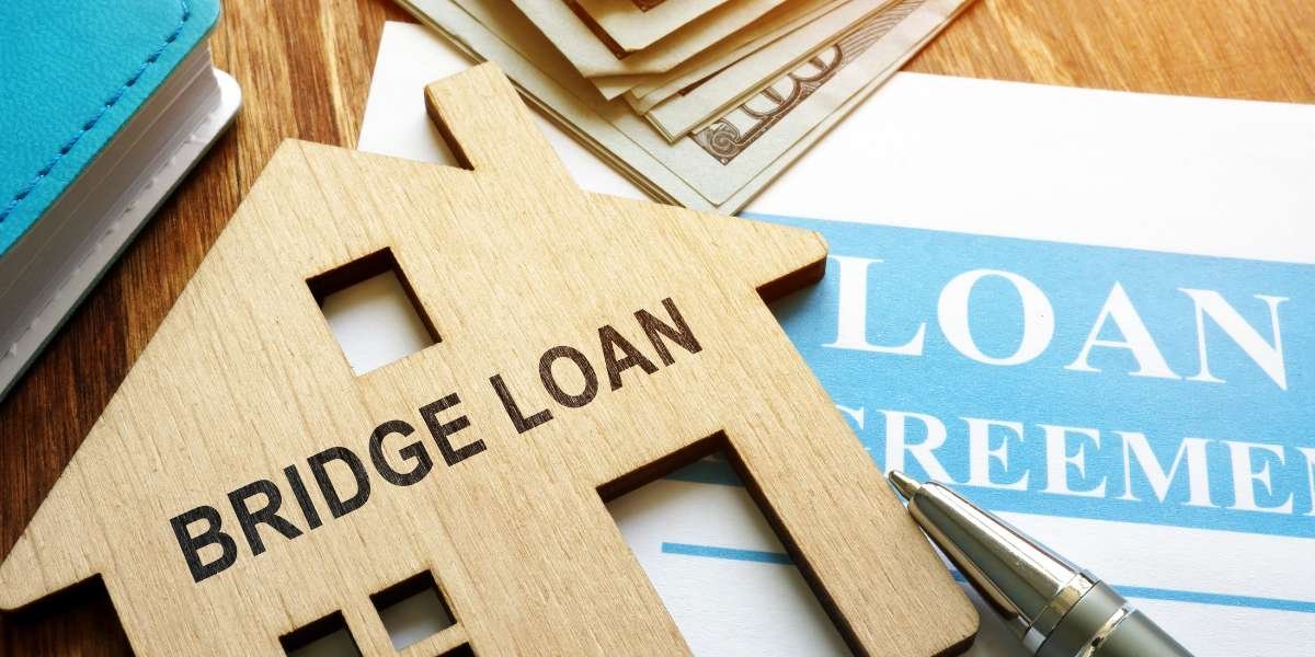 A wooden house cutout stamped with the words "BRIDGE LOAN" resting on a signed property loan agreement with cash in the background, explaining how bridging finance works in plain terms.