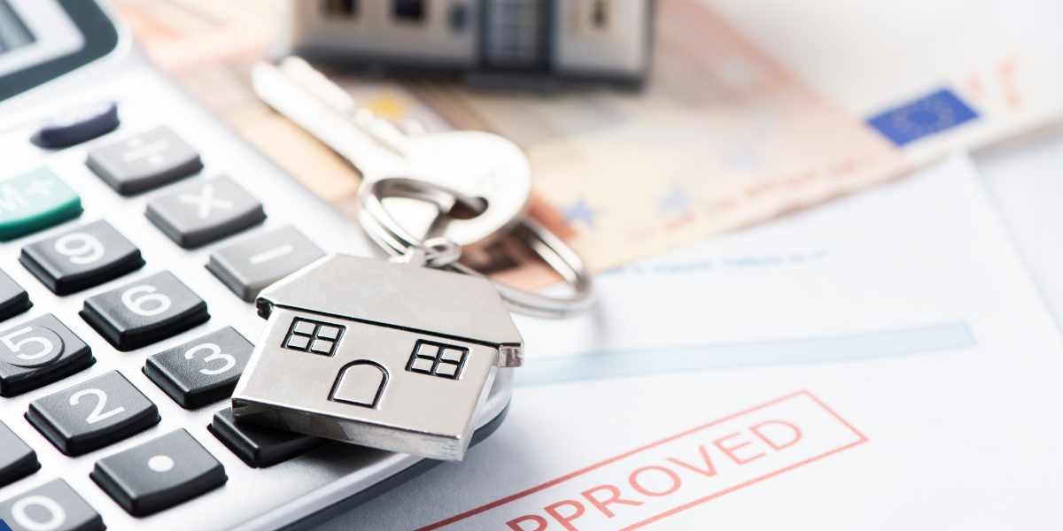Close-up of house keys and a calculator resting on a mortgage document stamped 'APPROVED', illustrating a successful Joint Borrower Sole Proprietor application in the UK.